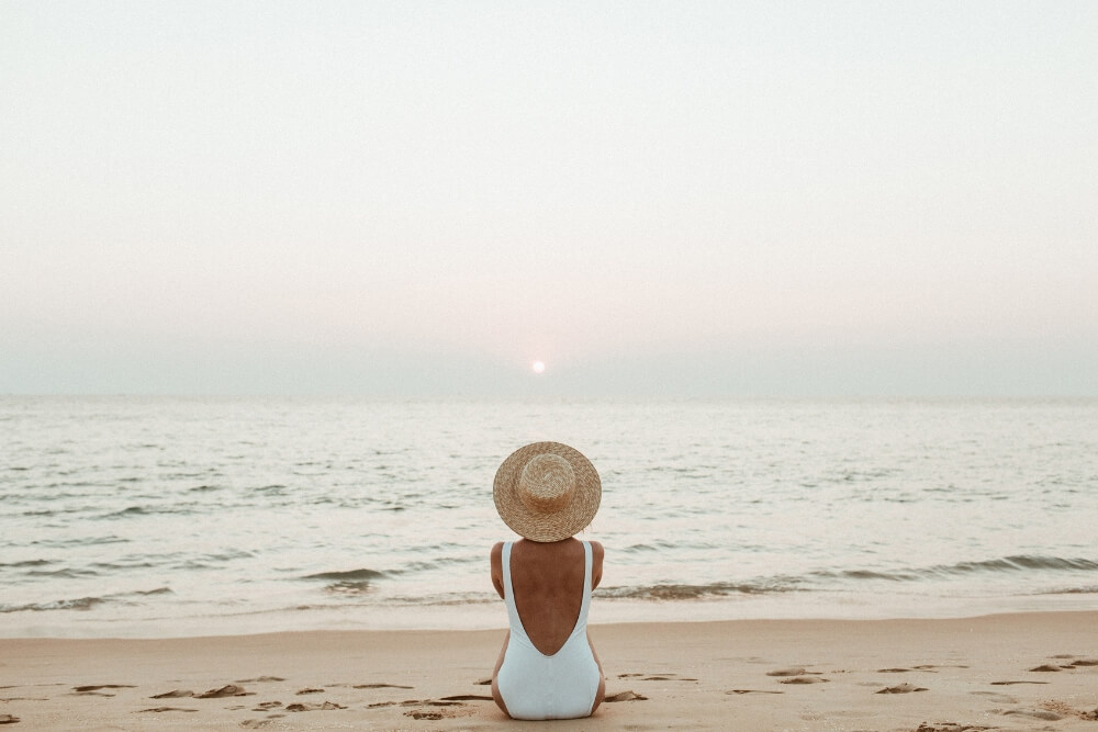 African women relaxing on beach vacation African women relaxing on beach wearing sunhat