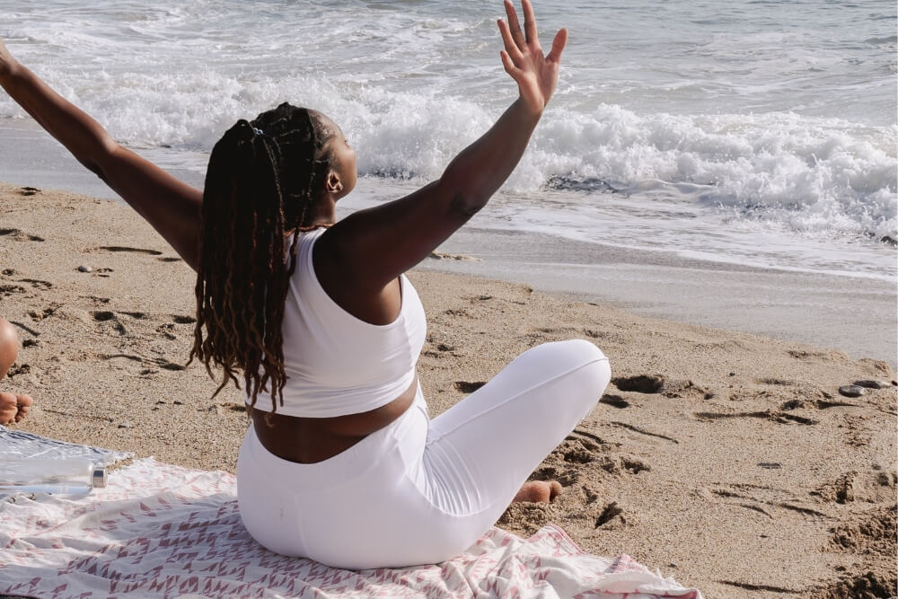 Beach Vacation African woman wearing white Co-ord Sets relaxing while siting at beach