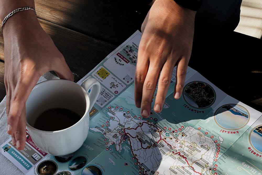 Untitled design (40) person holding white ceramic mug and map