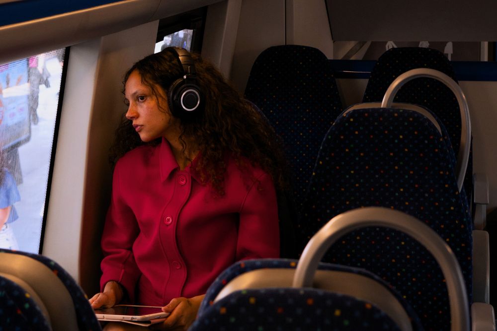 Untitled design (42) woman using a digital tablet on a train